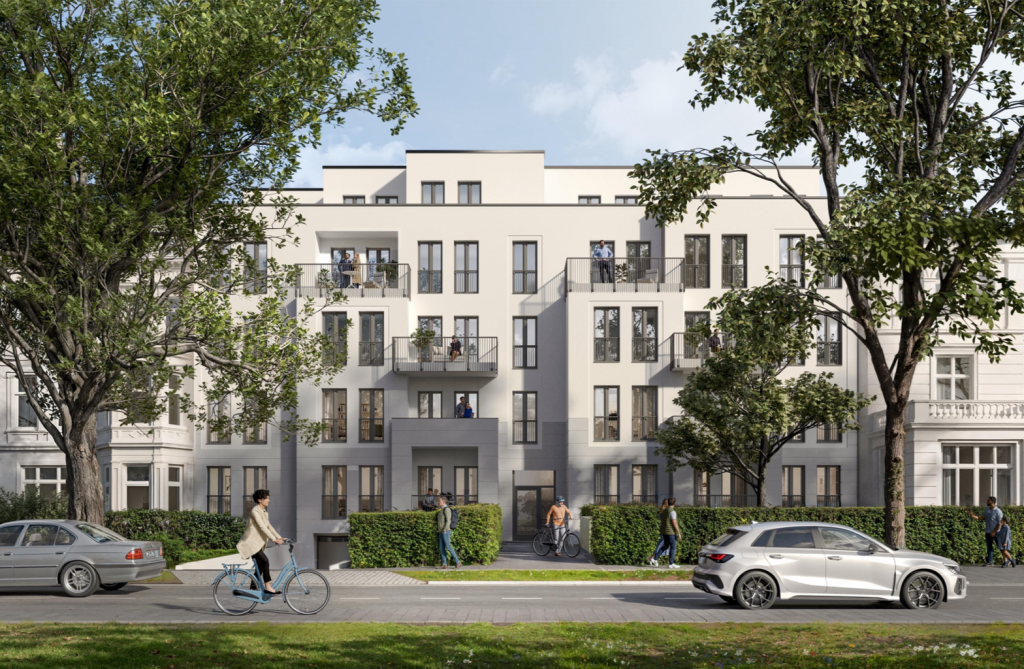 Ein modernes, weißes Wohnhaus mit Balkonen und großen Fenstern steht an einer begrünten Straße; Fußgänger und Radfahrer sind unterwegs.